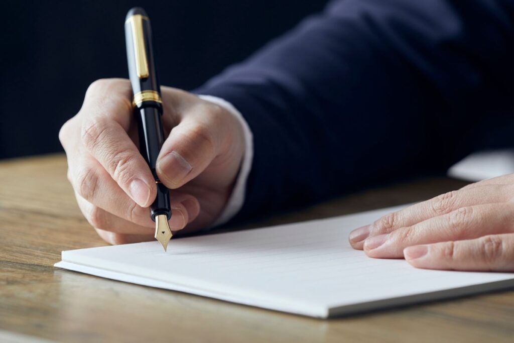 Segurado assinando apólice de seguro com caneta dourada após compreender todos os termos contratuais