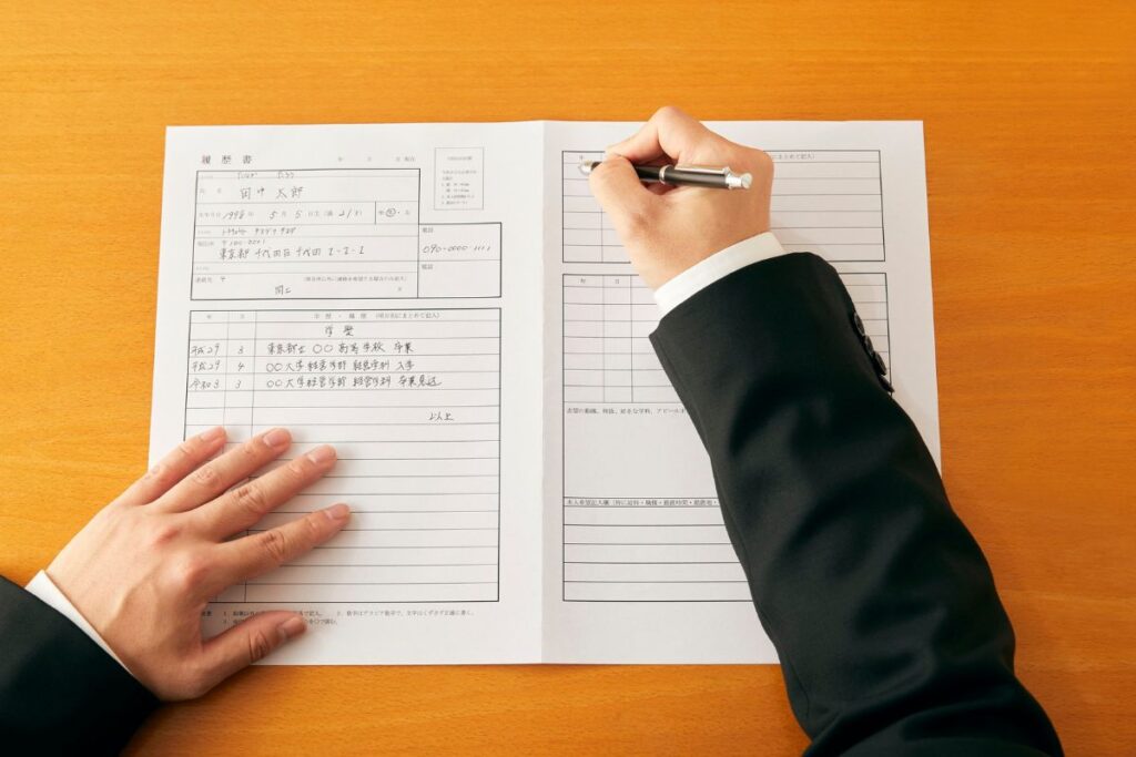 Profissional preenchendo uma apólice de seguros (Rirekisho), ilustrando o processo de proposta e formalização de um contrato de garantia no Japão.