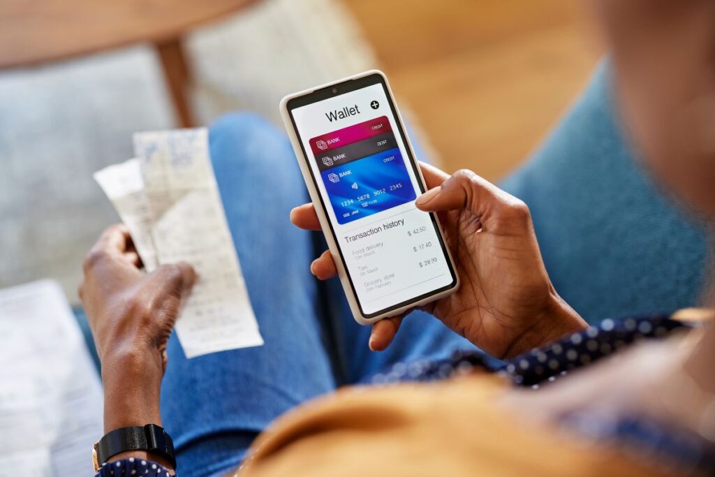 Usuário acessando aplicativo de carteira digital com cartões e histórico de transações. Revolução dos pagamentos móveis, e-pagamento e carteiras eletrônicas.