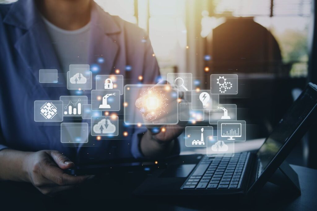 Visão digital da inovação com ícones de tecnologia (IA, Cloud, Segurança) sobre um laptop. O futuro digital a serviço da sua liberdade financeira.