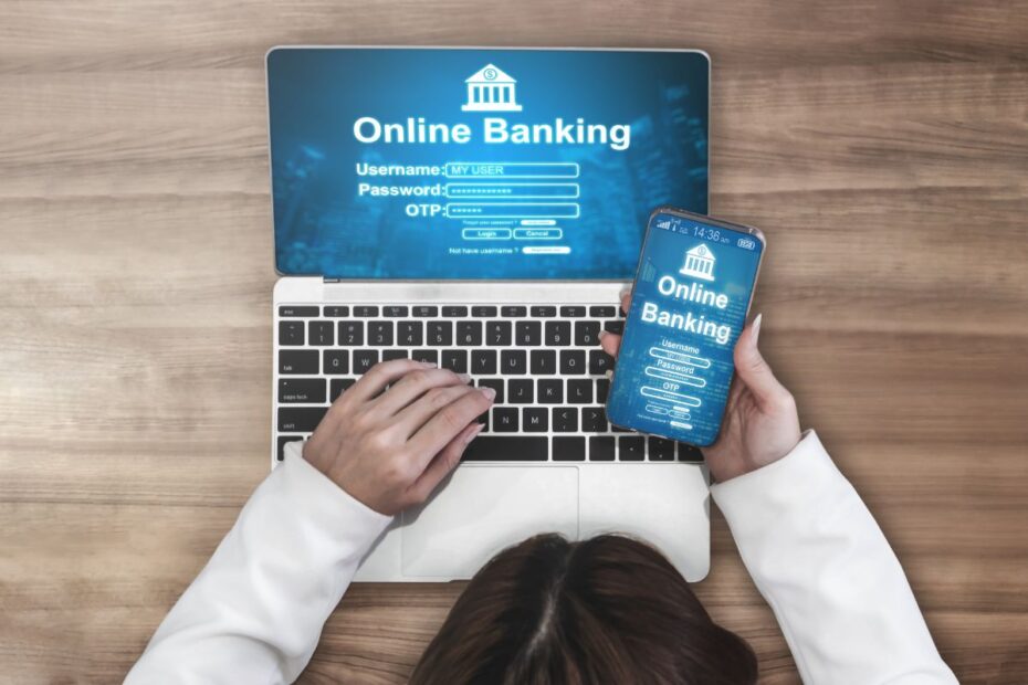Mulher usando laptop e smartphone para login em um aplicativo de online banking. Acesso digital rápido para sua liberdade financeira.