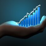 Mão segurando um gráfico de barras azul com linha ascendente, representando estratégias de rentabilidade e controle.