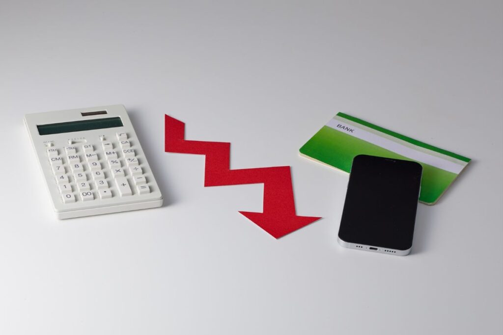 Seta vermelha para baixo entre calculadora e celular/caderneta, simbolizando novas dívidas ou queda financeira.